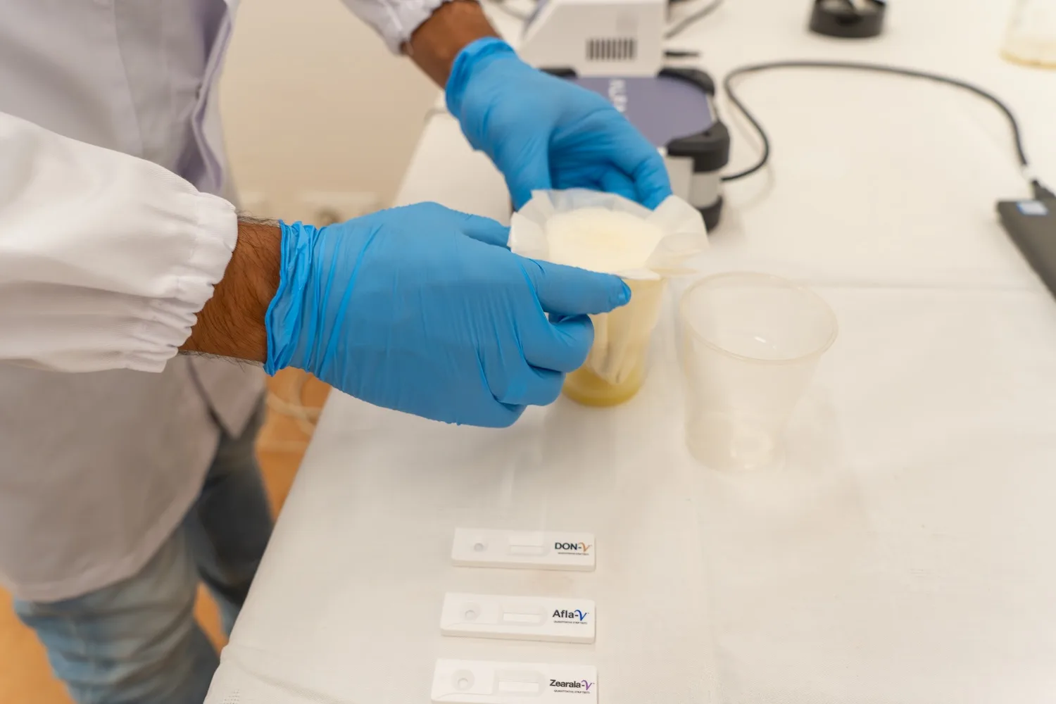 Dettaglio delle mani di un analista durante un'analisi del mangime in laboratorio